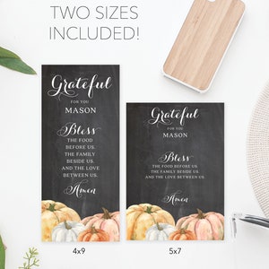 Puede incluir: Dos impresiones estilo pizarra con el texto "Grateful for you Mason, Bless the food before us...Amen" y calabazas en acuarela. Una impresi&oacute;n es de 10x23 cm, la otra de 13x18 cm. Tambi&eacute;n se ve una funda de tel&eacute;fono de madera.