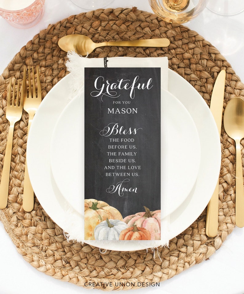 Puede incluir: Un lugar de mesa de Acci&oacute;n de Gracias con un plato blanco, utensilios dorados y una tarjeta decorativa. La tarjeta dice "Grateful for you Mason, Bless the food before us...Amen" con calabazas de acuarela. El lugar incluye un mantel individual tejido.