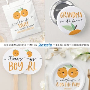 May include: Orange themed baby shower decorations with the text "love is sweet" and "a little cutie is on the way".