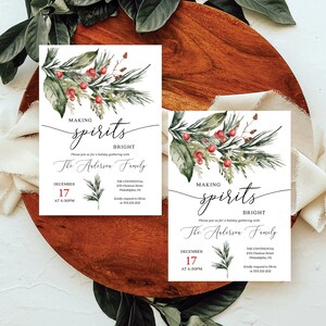 Pu&ograve; includere: Inviti per una festa natalizia con elementi floreali ad acquerello e bacche rosse. Il testo recita "Making Spirits Bright" e include data, ora e luogo. Il design ha un'estetica festosa ed elegante.