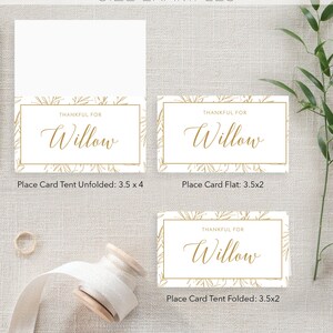 Puede incluir: Tres ejemplos de tarjetas de lugar con un dise&ntilde;o floral dorado y el texto "Thankful for Willow". Las tarjetas de lugar se muestran en tres tama&ntilde;os diferentes: desplegada, plana y doblada. La tarjeta de lugar desplegada mide 8,9 cm por 10,2 cm, la tarjeta de lugar plana mide 8,9 cm por 5,1 cm y la tarjeta de lugar doblada mide 8,9 cm por 5,1 cm.