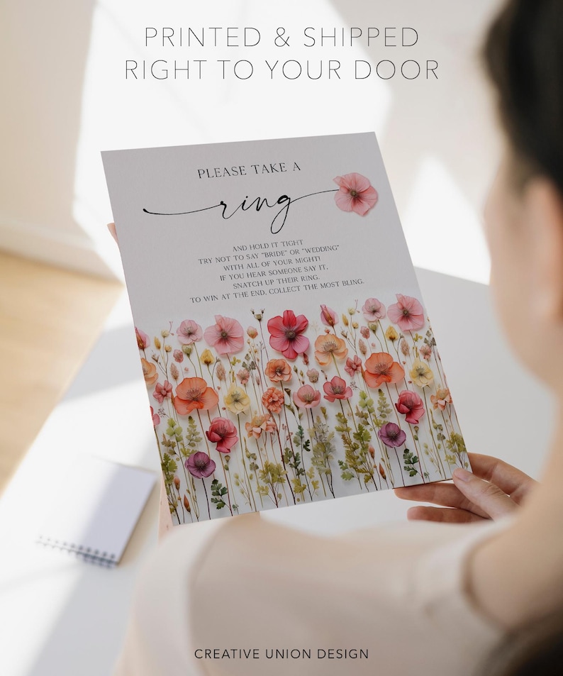 K&ouml;nnte beinhalten: Eine Hochzeitsspielkarte mit floralen Illustrationen und dem Text "PLEASE TAKE A ring". Die Karte enth&auml;lt Anweisungen und ein Aquarell-Blumenmuster in Rosa, Orange und Gelb. Der Text "PRINTED & SHIPPED RIGHT TO YOUR DOOR" steht oben.