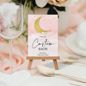 Puede incluir: Un cartel imprimible rosa y dorado con una luna creciente y estrellas. El cartel dice "Crea cualquier cartel personalizado e imprime tantos como necesites!"