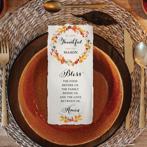 May include: A Thanksgiving place card with a watercolor wreath of fall leaves and berries. The text reads "So very Thankful for you Mason Bless the food before us. The family beside us. And the love between us. Amen."