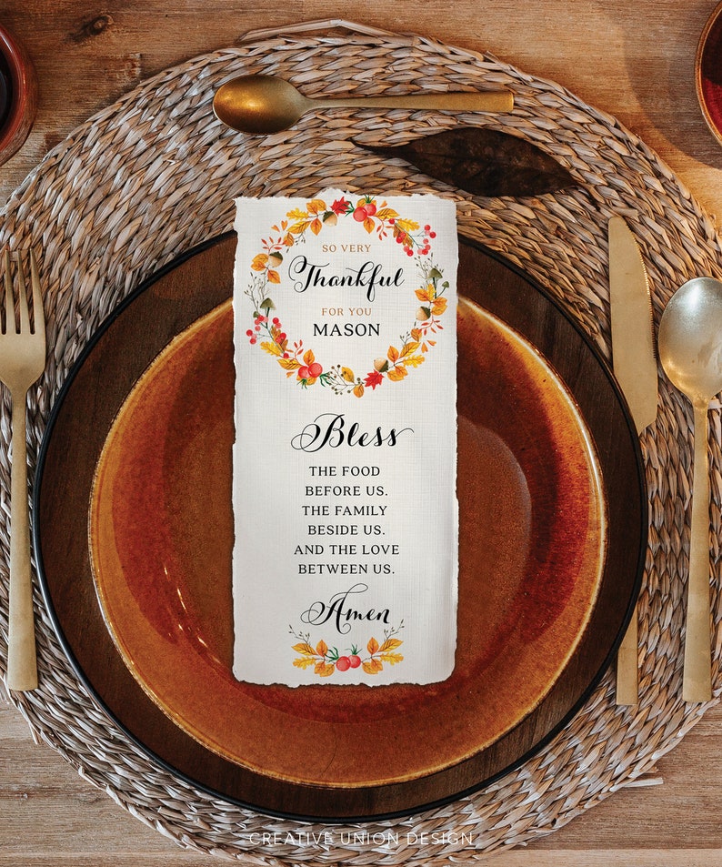 May include: A Thanksgiving place card with a watercolor wreath of fall leaves and berries. The text reads "So very Thankful for you Mason Bless the food before us. The family beside us. And the love between us. Amen."