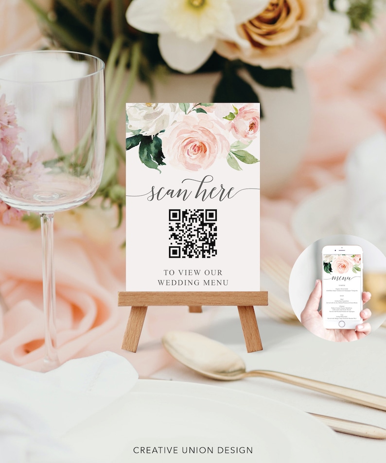 Op de afbeelding: Een witte kaart met een bloemenontwerp en een QR-code. De kaart zegt "scan here" en "to view our wedding menu".