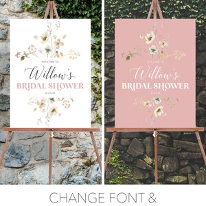 May include: Two bridal shower signs on wooden easels. One sign has a white background, the other is pink. Both signs read "Welcome to Willow's Bridal Shower" with floral accents and the date 01.23.45. The bottom of the image reads "CHANGE FONT & BACKGROUND COLORS!"