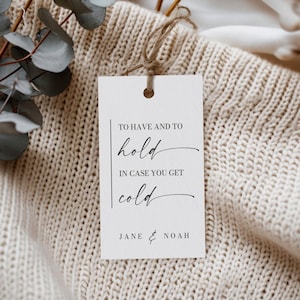 May include: A white card with black text that reads "To have and to hold in case you get cold" with the names Jane & Noah at the bottom.