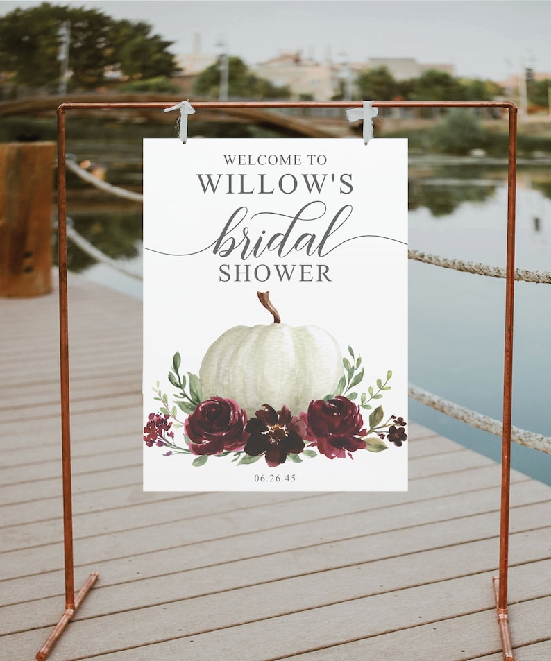 May include: White pumpkin with burgundy floral accents and greenery. Text reads "Welcome to Willow's bridal shower 06.26.45".
