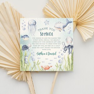 May include: A thank you card with an ocean theme. The card features a whale, jellyfish, octopus, seahorse, turtle, and crab. The text on the card reads "Thank You So Much" and "Sophia & Daniel".