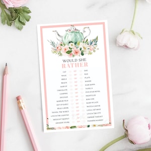 Puede incluir: Una tarjeta de juego imprimible rosa y verde con el texto "Would She Rather" y una lista de preguntas con dos opciones cada una. La tarjeta presenta una ilustración de acuarela de una tetera con flores.