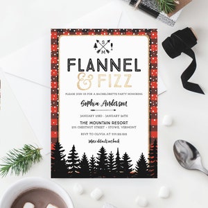 K&ouml;nnte beinhalten: Eine Einladung zur Junggesellinnenabschiedsparty mit rustikalem Thema. Die Einladung zeigt einen rot-schwarz karierten Rand mit den Worten "Flannel & Fizz" in Schwarz und Gold. Die Einladung enth&auml;lt Eventdetails und eine Waldsilhouette.