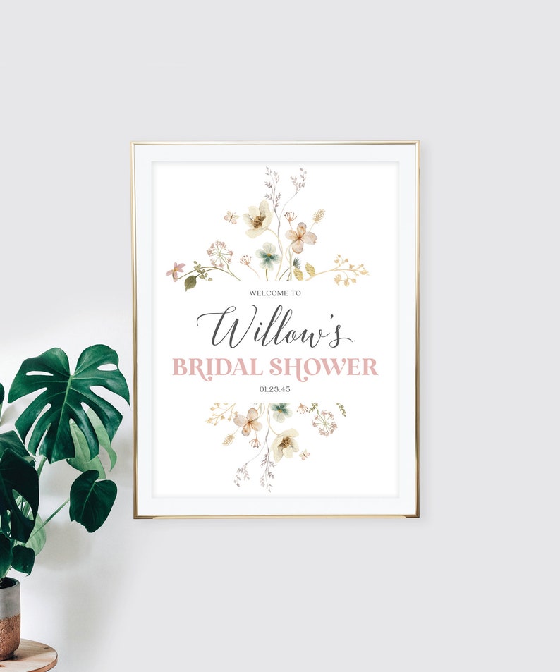 May include: A framed print with a gold border, featuring the text "Welcome to Willow's Bridal Shower" in elegant script and a soft pink color. The design includes watercolor floral elements in muted tones, creating a delicate and romantic aesthetic.