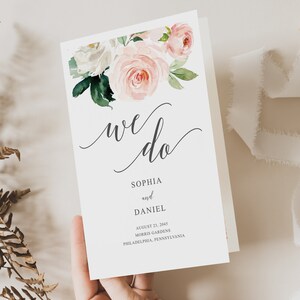 Puede incluir: Una tarjeta de anuncio de boda con un diseño floral en tonos rosa y blanco. El texto dice "we do" en escritura cursiva, seguido de los nombres Sophia y Daniel, la fecha 23 de agosto de 2045, la ubicación Morris Gardens, Filadelfia, Pensilvania, y las palabras "Creative Union Design".