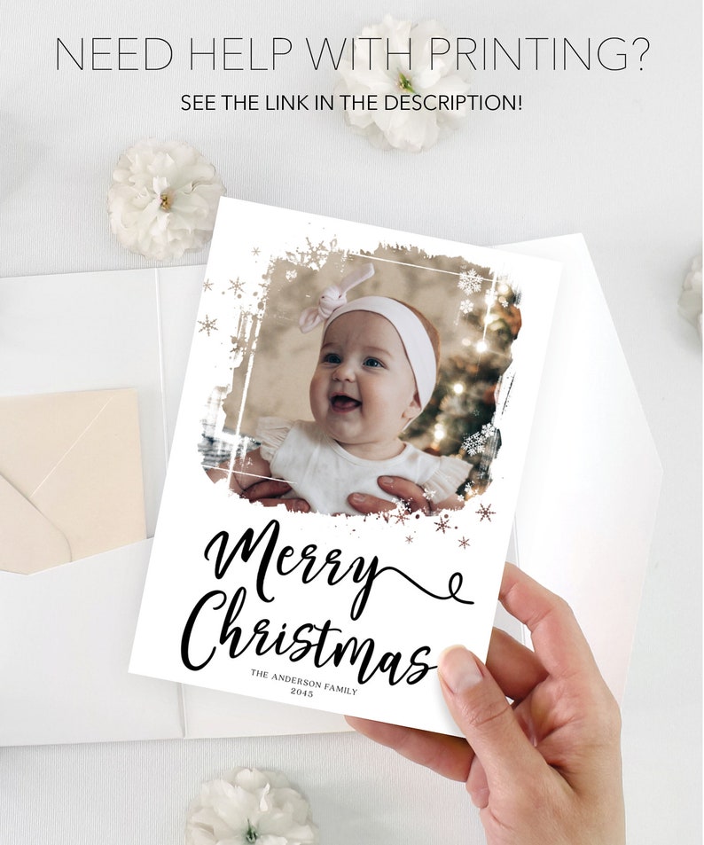 May include: A white Christmas card with a photo of a baby, the words "Merry Christmas" in black script, and the family name. The card is held by a hand. Text at the top reads "NEED HELP WITH PRINTING? SEE THE LINK IN THE DESCRIPTION!"