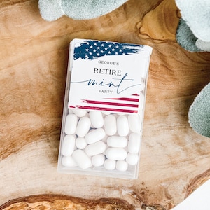 May include: A clear plastic container filled with white mints. The container has a label with a red, white, and blue American flag design and the text "George's Retire Mint Party".