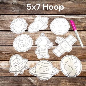 May include: A set of white space-themed felt cutouts featuring a sun, rocket, moon, galaxy, astronaut, satellite, UFO, Saturn, and Earth, accompanied by a pink dry erase marker. The text 5x7 Hoop is printed at the top of the collection.