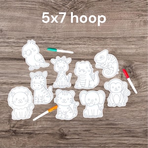 May include: A collection of white, outline-style animal cutouts, including a parrot, giraffe, zebra, lion, tiger, elephant, monkey, and chameleon. The text "5x7 hoop" is at the top. Several colored markers are also present.