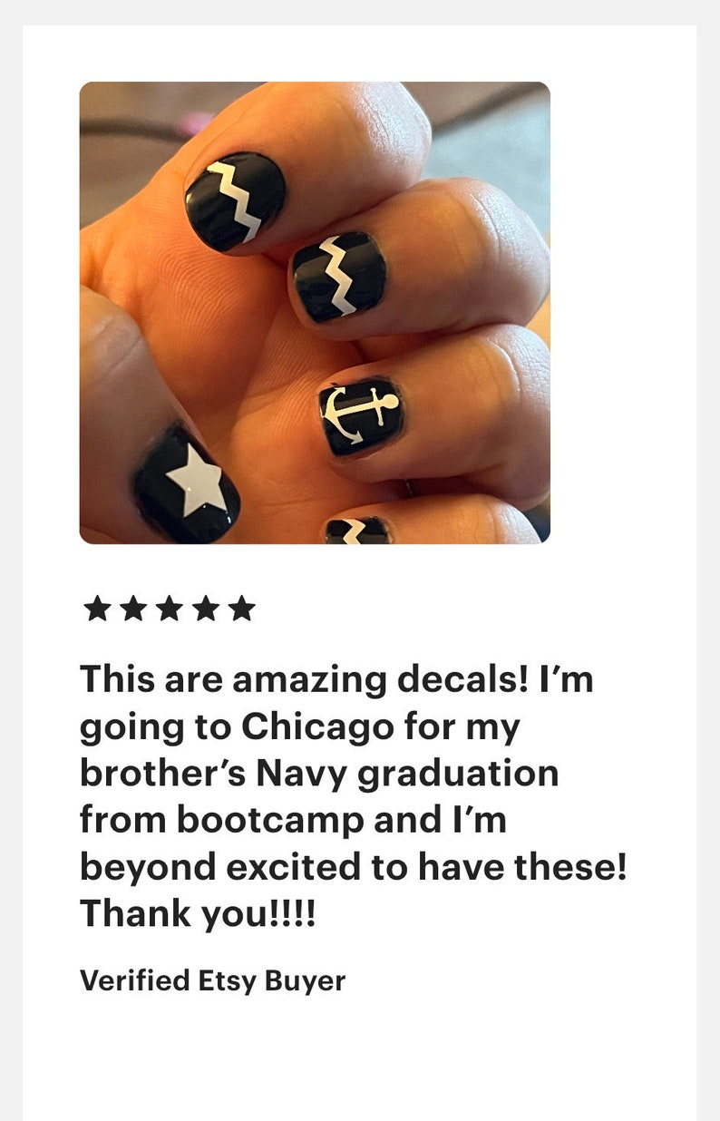 May include: Black nail decals featuring white graphic designs including a five-pointed star, a nautical anchor, and a zigzag pattern. These adhesive nail art stickers are applied to the fingernails, showcasing a high-contrast monochrome aesthetic.