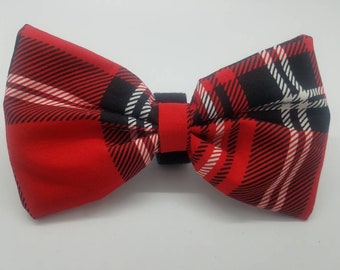 May include: Red, black, and white plaid bow tie. The bow tie is made of fabric and has a black elastic band.