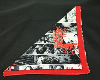 May include: A red and white bandana with a black and white comic book print featuring the words "The Walking Dead".