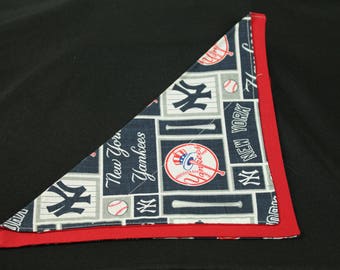 May include: A red and blue fabric bandana with a New York Yankees theme. The bandana features a baseball, bats, and the team's logo.