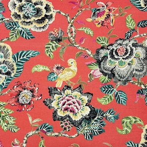 May include: A red fabric with a floral pattern featuring black, white, and green flowers, leaves, and branches. A small yellow bird is perched on a branch.