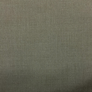 May include: Close-up of a textured fabric in a muted olive green color. The fabric has a subtle ribbed pattern running horizontally across the surface, creating a visual texture. The weave appears tight and durable, suitable for various textile applications.