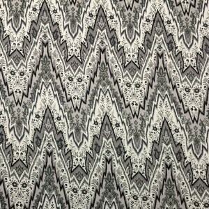 May include: A white fabric with a black and gray paisley pattern. The pattern is a repeating design of stylized flowers and leaves.