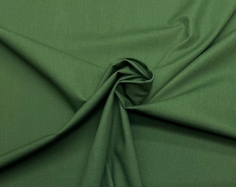 May include: A close-up of a dark green fabric with a smooth texture. The fabric is folded and draped, creating a soft, flowing look.