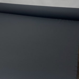 May include: A roll of dark gray fabric with a textured surface.