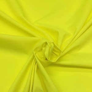 May include: Bright yellow fabric with soft folds and a gathered center. The fabric has a smooth texture and a vibrant, solid color. The material appears to be lightweight and suitable for clothing or home decor projects.