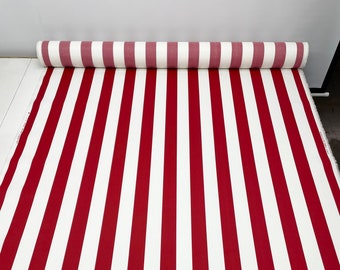 May include: Red and white striped fabric rolled up. The fabric has a classic striped pattern.