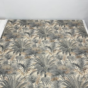 May include: A beige fabric with a repeating pattern of dark grey palm trees. The palm trees are stylised and have a tropical feel.