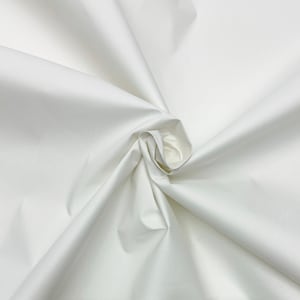 May include: White cotton fabric, smooth and wrinkle-free, with a soft, luxurious feel. The fabric is folded and draped, showcasing its texture and drape.