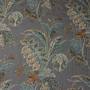 May include: A gray fabric with a floral pattern featuring blue, orange, and brown leaves. The fabric has a subtle texture.