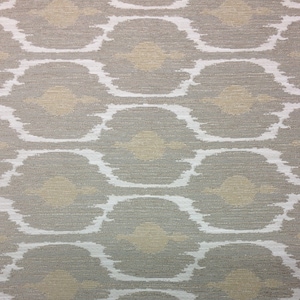May include: A close-up of a gray and beige fabric with a repeating pattern of ovals. The fabric has a subtle sheen and a textured surface.