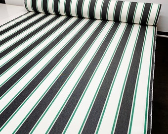May include: White fabric with black and green stripes. The fabric is rolled up and the stripes are running vertically.