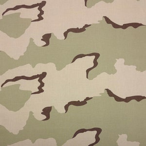 Puede incluir: Un patrón de tejido de camuflaje con colores marrón, verde y beige. El patrón está formado por formas y líneas irregulares.