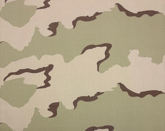 May include: A camouflage fabric pattern with brown, green, and beige colors. The pattern is made up of irregular shapes and lines.