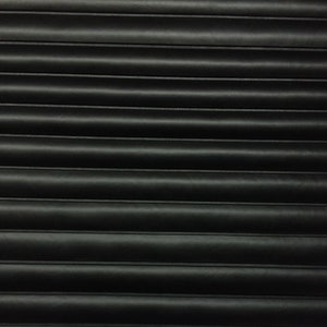 May include: Black corrugated metal surface with horizontal lines.