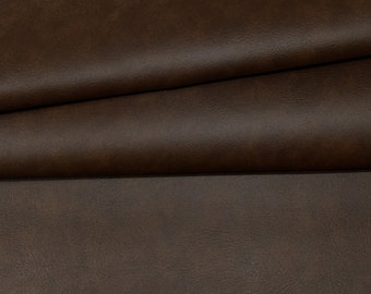 Puede incluir: Primer plano de una tela de cuero sintético marrón con una superficie texturizada.