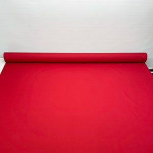 May include: A roll of red fabric, likely for crafts or upholstery.