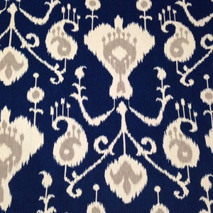 May include: A blue and white fabric with a repeating ikat pattern. The pattern features a stylized floral design with a central diamond shape.