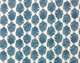 Puede incluir: Una tela blanca con un patrón repetitivo de diseños florales azules. Los diseños florales son intrincados y detallados, creando un aspecto clásico y elegante.