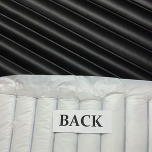 May include: White padded envelope with the word "BACK" printed on a white label.