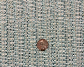 May include: A close-up of a light blue and white woven fabric with a subtle shimmer. A US penny is placed on the fabric for scale.
