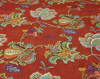 May include: Red fabric with a floral pattern. The flowers are in shades of orange, green, blue, and purple. The background is a solid red.