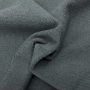 May include: Close-up of a dark gray, textured fabric. The fabric is soft and fuzzy, with a slightly nubby texture.