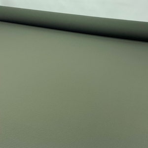 May include: A roll of olive green fabric, unrolled on a white surface. The fabric has a subtle texture and is suitable for various crafting and sewing projects. The roll is positioned horizontally, showcasing the material's width and color.